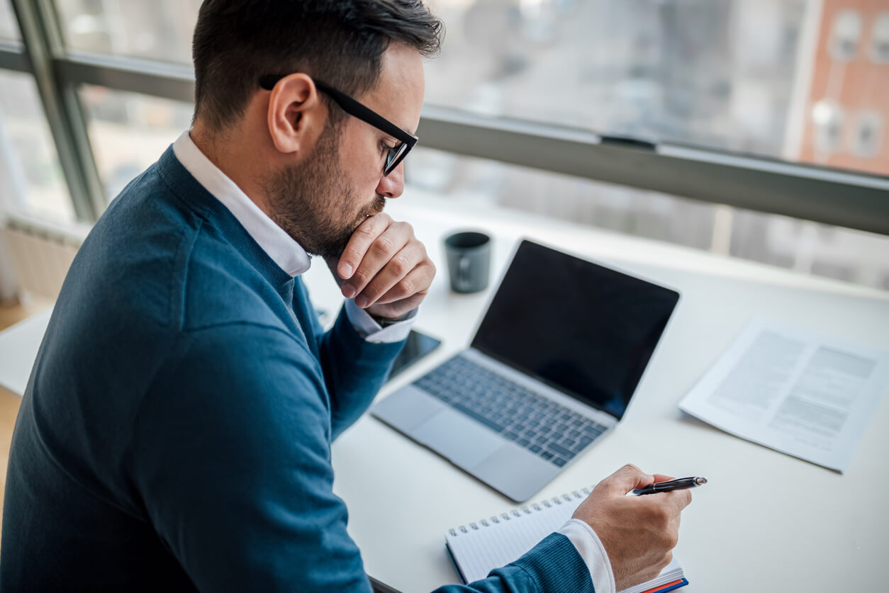Šta ozbiljan poslovni sajt ne sme da ignoriše | WordPress savet A business owner looking at a laptop with a partially built WordPress website, highlighting common mistakes during website creation.
